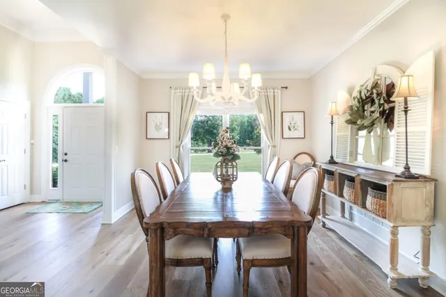 a view of a dining room with furniture a chandelier and wooden floor