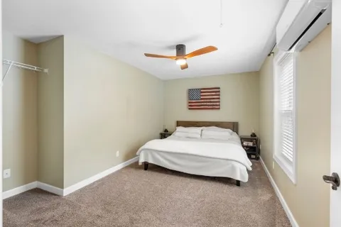 a bedroom with a bed and a ceiling fan