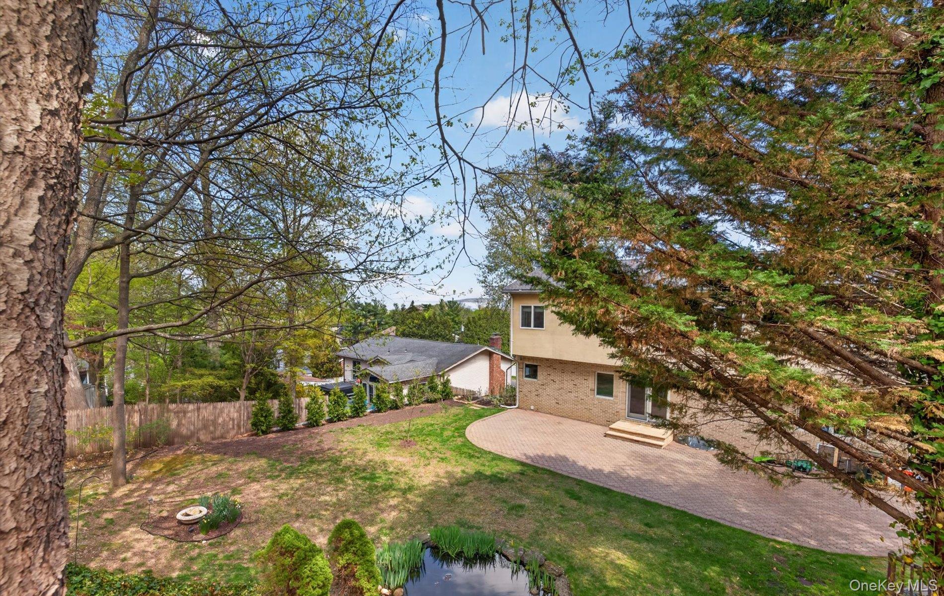 16 East Slope Road Bayville, NY 11709 - Photo 39 of 48 Expansive outdoor area featuring a paver patio, lush lawn, and mature trees