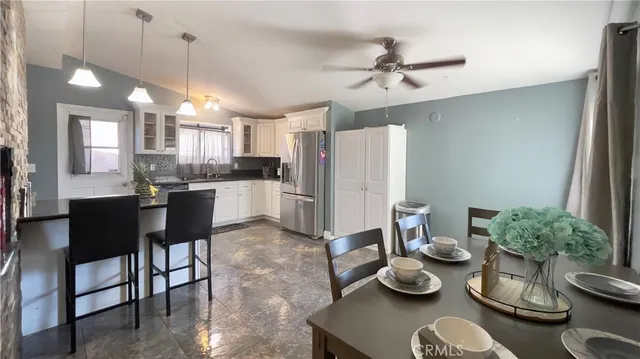 a kitchen with stainless steel appliances kitchen island granite countertop a dining table and chairs