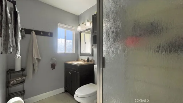 a bathroom with a granite countertop toilet a sink and shower