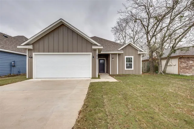 a front view of a house with a garden and yard