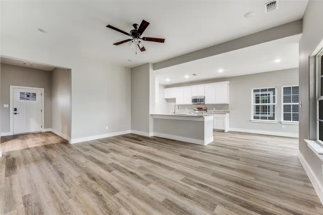 a view of a kitchen with a sink dishwasher and a stove with wooden floor