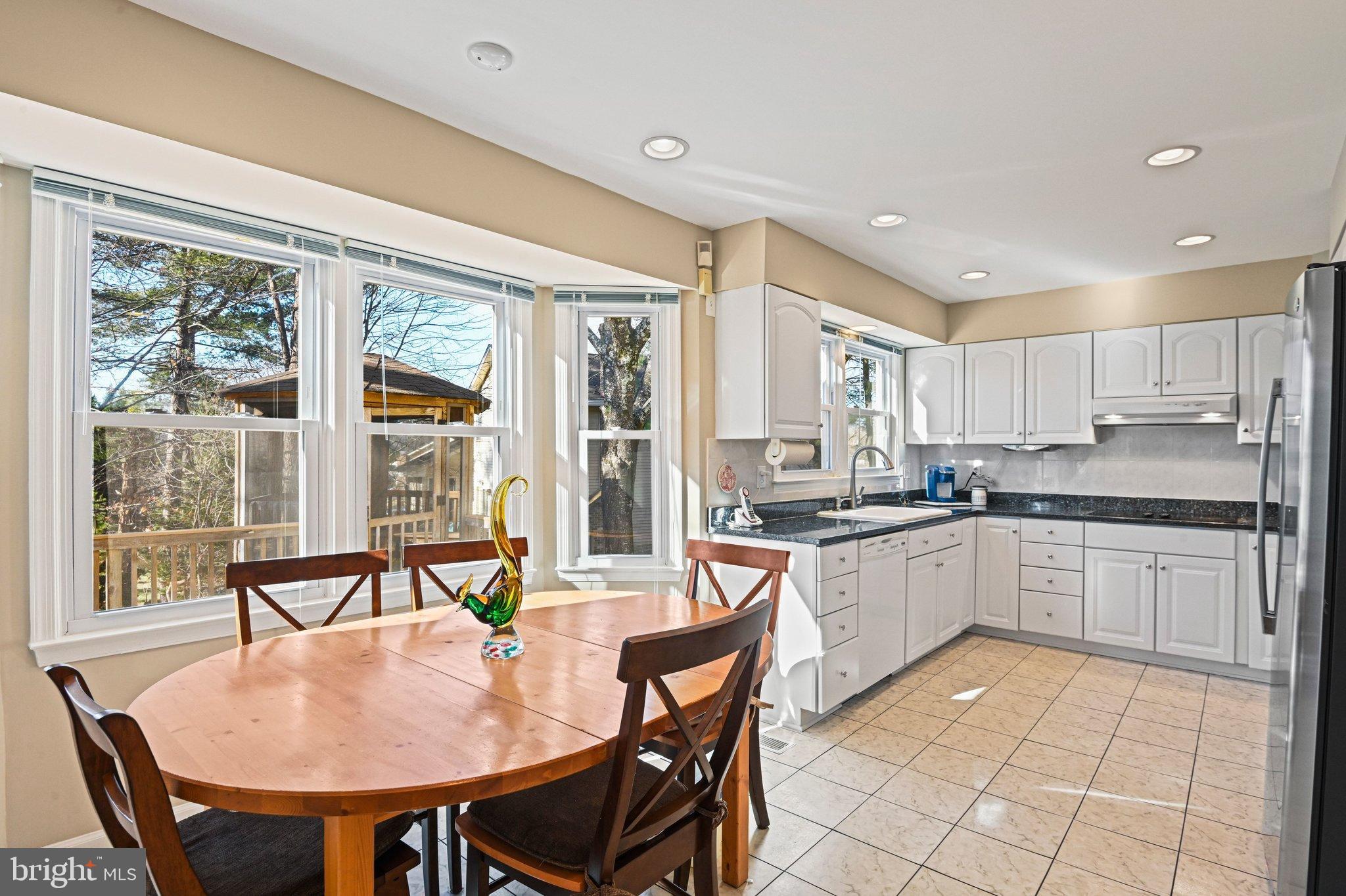 2707 Glencroft Road Vienna, VA 22181 - Photo 18 of 53 a kitchen with a dining table chairs and refrigerator