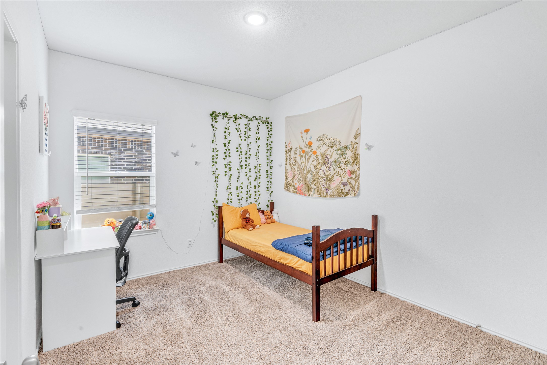 212 Saddle Mountain Road Georgetown, TX 78628 - Photo 7 of 30 A well-lit bedroom features plush carpeting and a large window providing ample natural illumination.