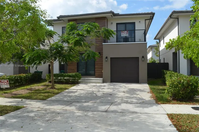 a front view of a house with a yard and a garage
