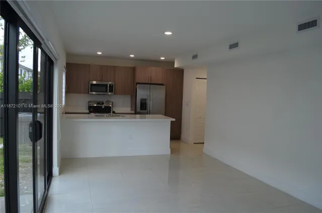 a large kitchen with a refrigerator a stove and a sink