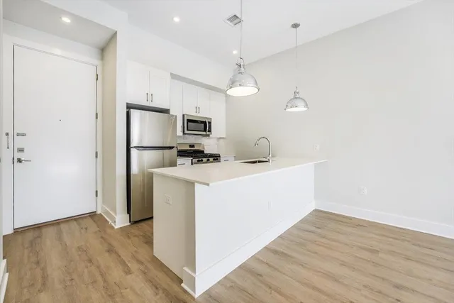 a view of kitchen with microwave and refrigerator