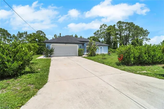 a front view of a house with a yard and trees