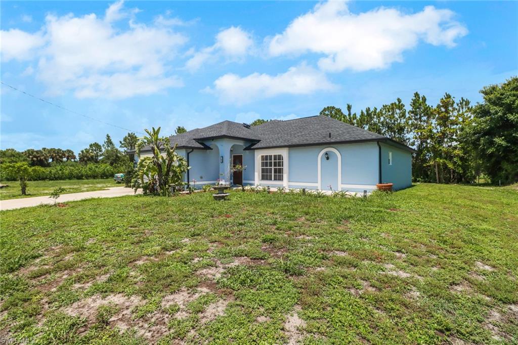 765 Aprile Avenue South Lehigh Acres, FL 33974 - Photo 2 of 32 a front view of a house with garden