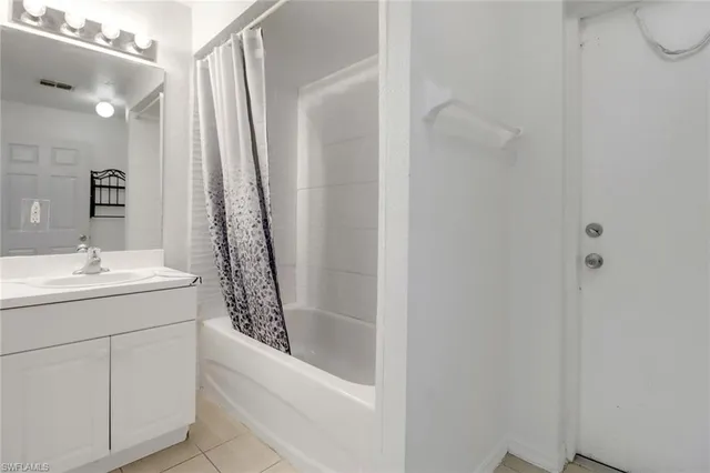 a bathroom with a granite countertop sink a mirror and shower