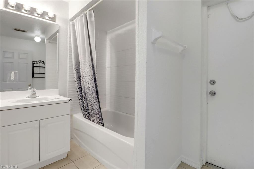 765 Aprile Avenue South Lehigh Acres, FL 33974 - Photo 21 of 32 a bathroom with a granite countertop sink a mirror and shower