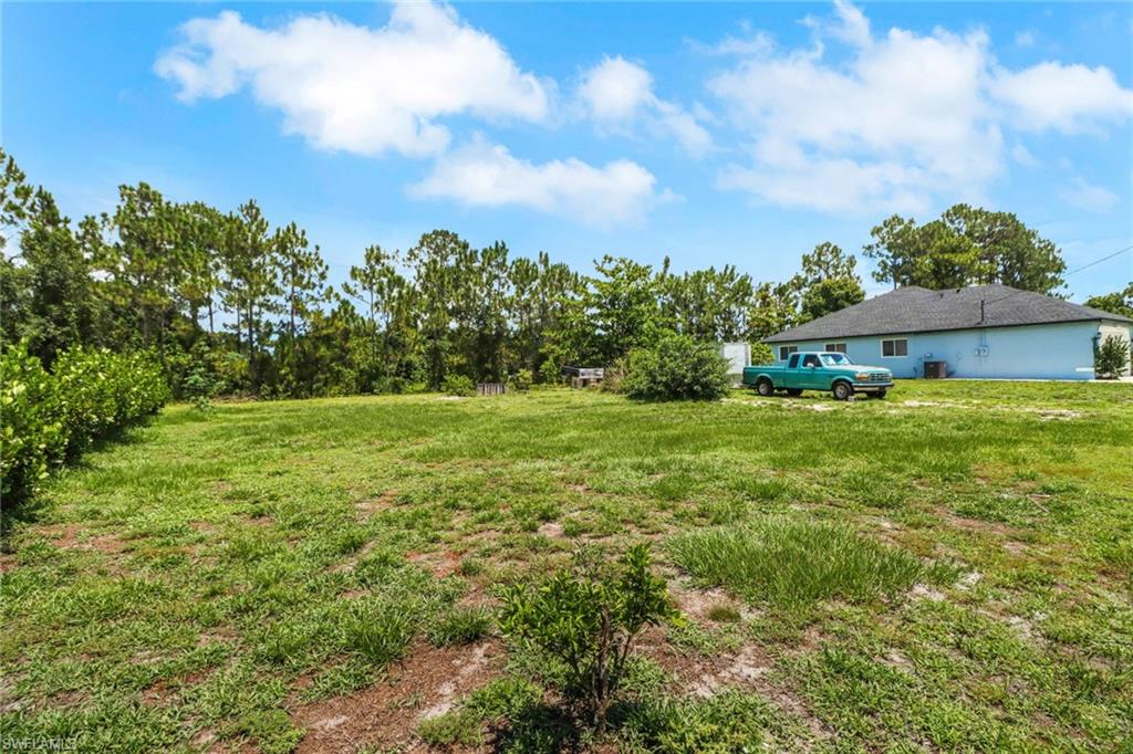 765 Aprile Avenue South Lehigh Acres, FL 33974 - Photo 30 of 32 a backyard of a house with lots of green space