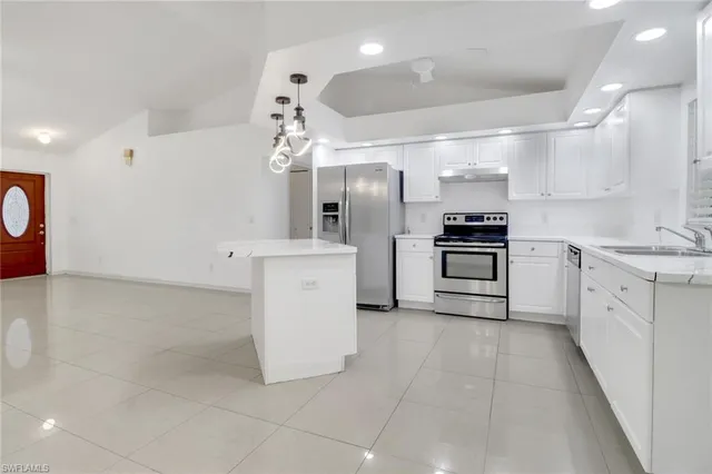 a kitchen with a sink and white cabinets