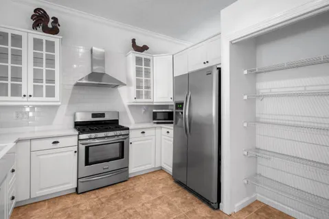 a kitchen with granite countertop a refrigerator stove top oven and sink