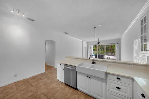 a kitchen with stainless steel appliances a refrigerator a sink a stove and white cabinets