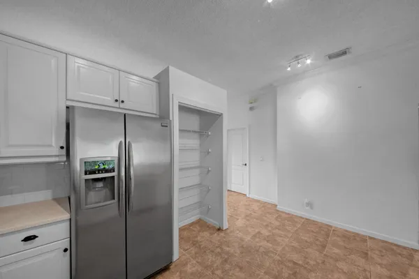 a large white kitchen with a sink and stainless steel appliances