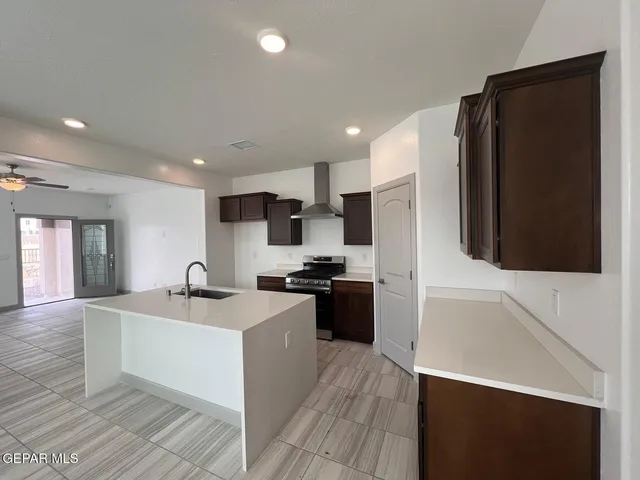 a large kitchen with stainless steel appliances kitchen island a sink dishwasher a refrigerator and a stove with wooden floor