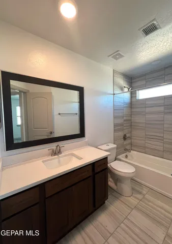 a bathroom with a double vanity sink toilet mirror and shower
