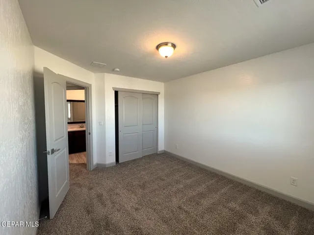 an empty room with windows and closet