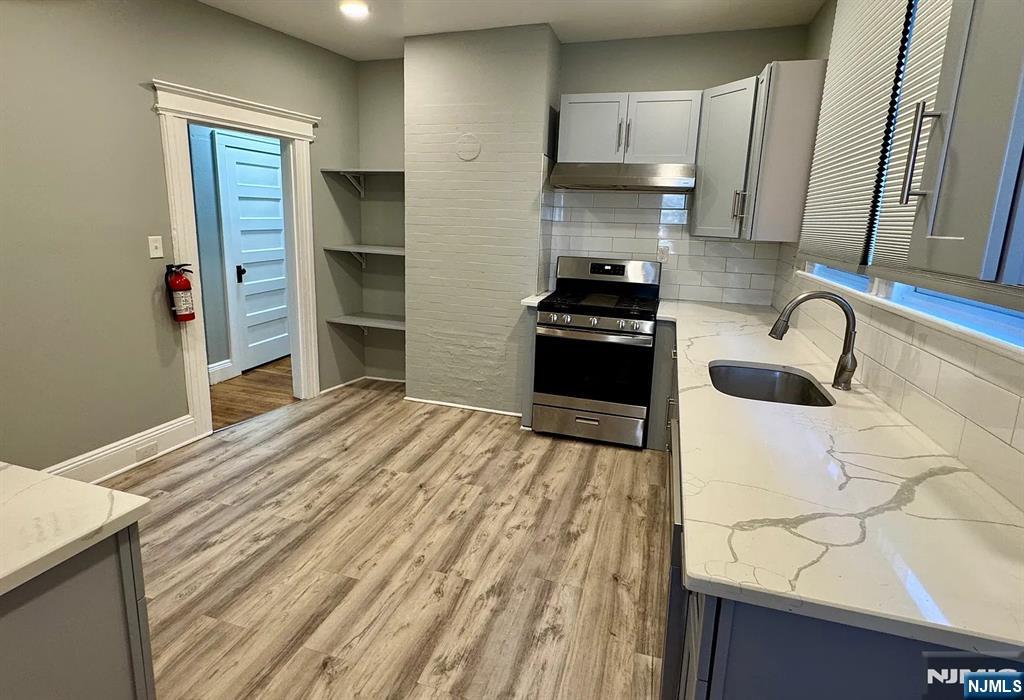57 Maolis Avenue, Unit 2 Bloomfield, NJ 07003 - Photo 16 of 22 a kitchen with granite countertop a sink stainless steel appliances and cabinets