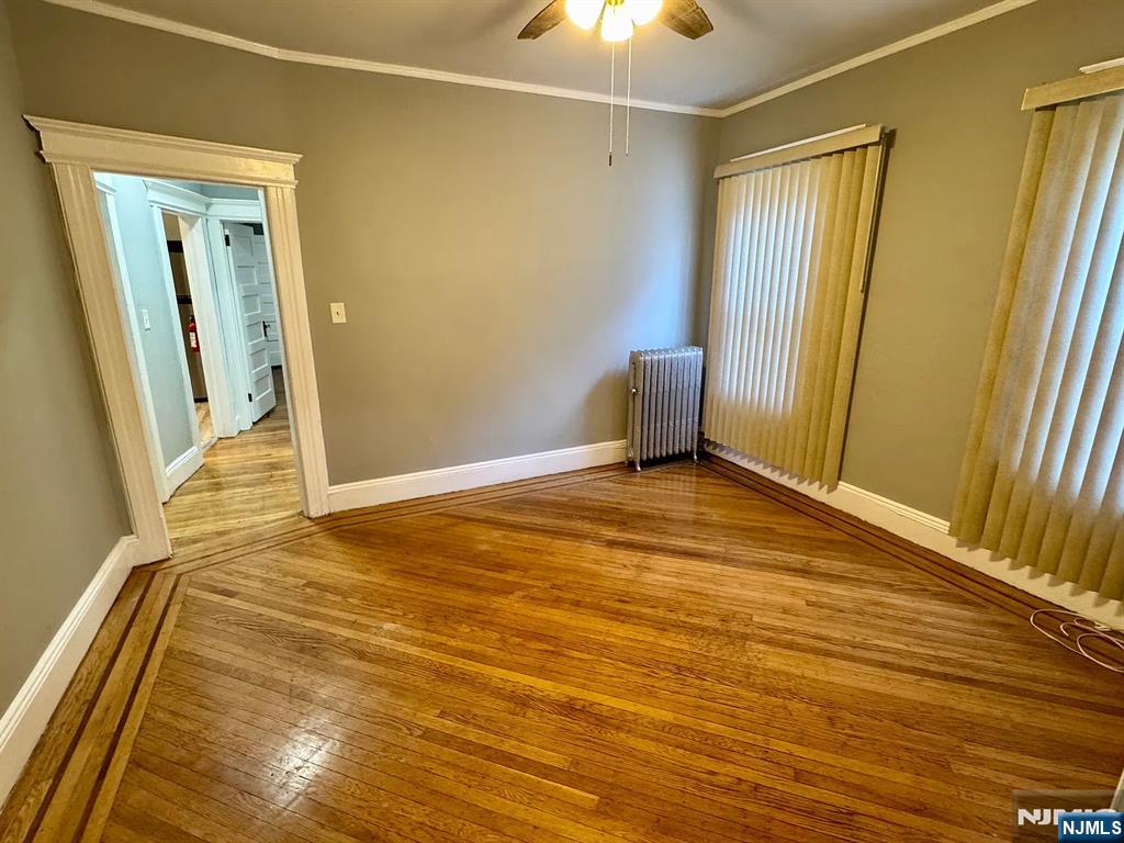 57 Maolis Avenue, Unit 2 Bloomfield, NJ 07003 - Photo 6 of 22 a view of an empty room with wooden floor and a window