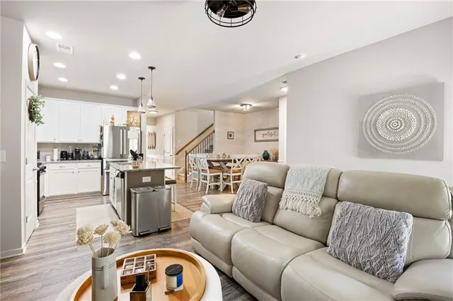 a living room with furniture and a view of kitchen