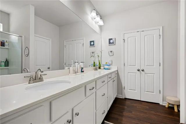 a spacious bathroom with a double vanity sink mirror and hardwood