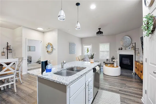 a kitchen with a sink dishwasher and a fireplace with wooden floor