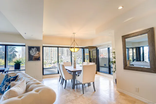 a living room with furniture a flat screen tv and floor to ceiling windows