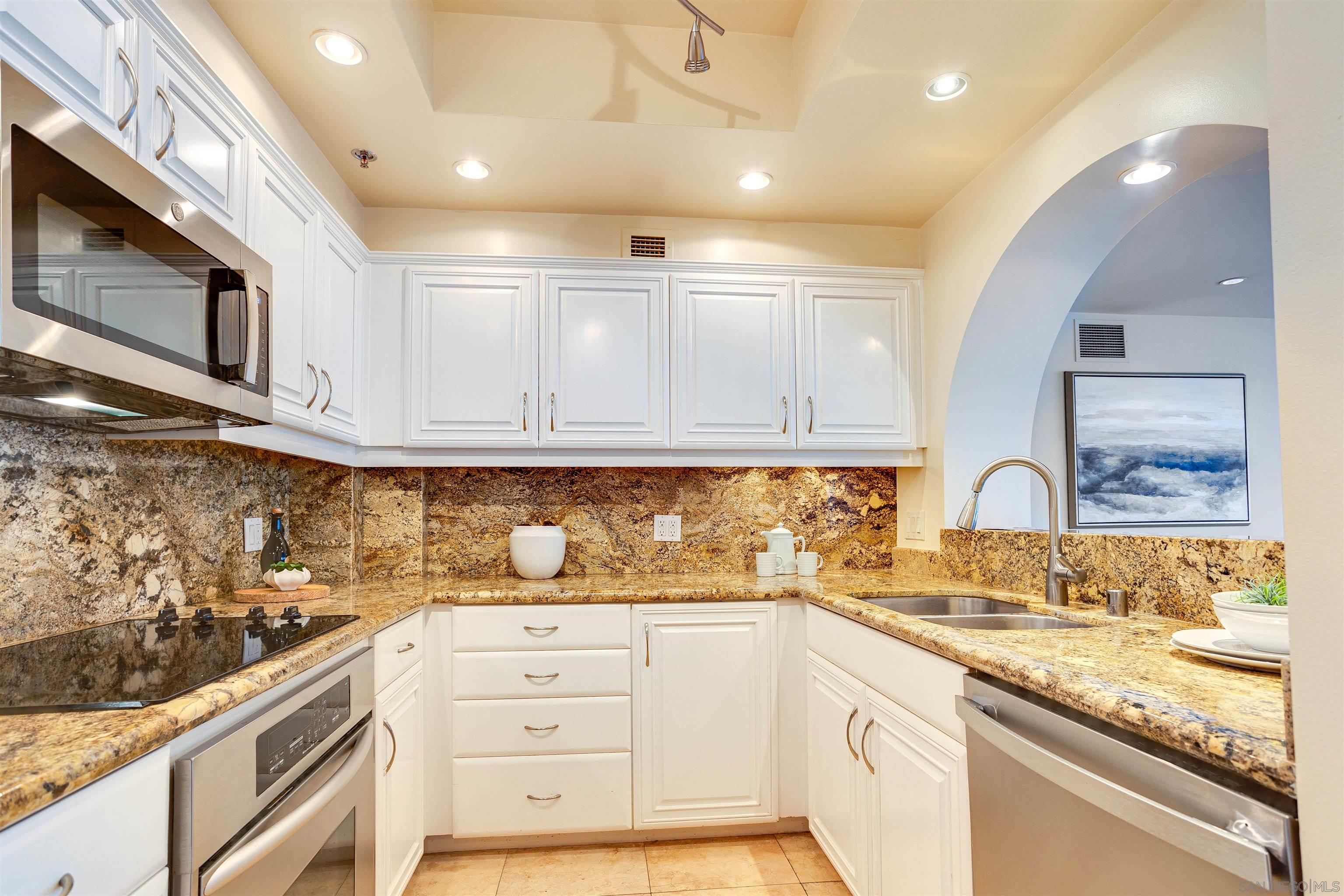 100 Harbor Drive, Unit 505 San Diego, CA 92101 - Photo 9 of 33 a kitchen with stainless steel appliances granite countertop a sink and cabinets with wooden floor