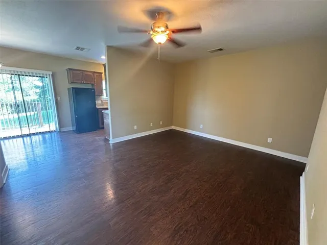 a view of an empty room with window and wooden floor