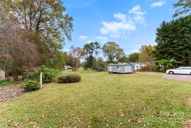 an aerial view of residential house with outdoor space and trees all around