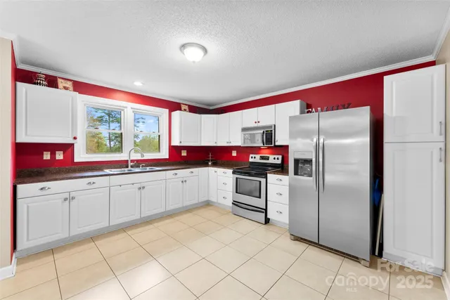 a kitchen with granite countertop a refrigerator and a sink