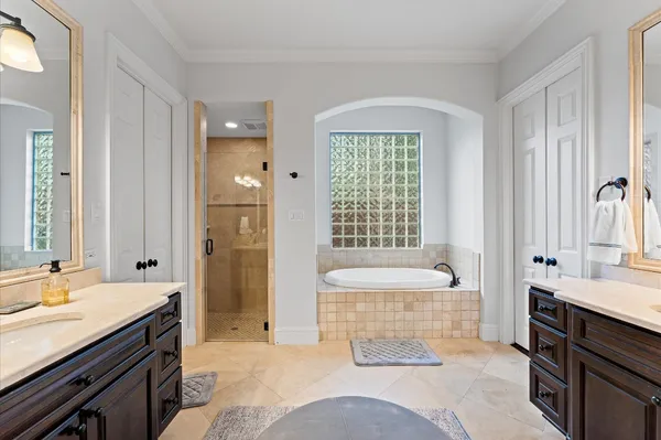 a spacious bathroom with a tub sink and mirror