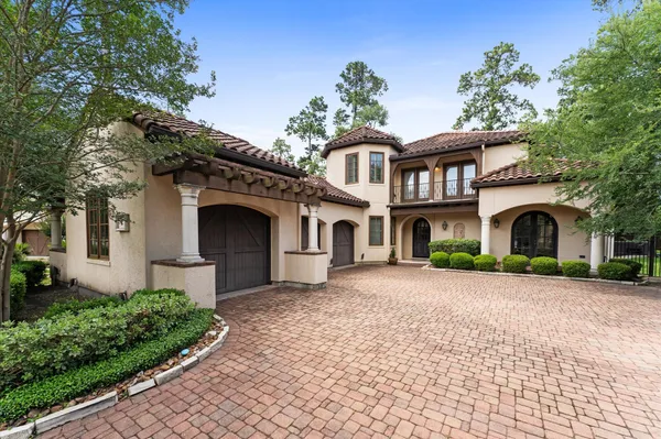a front view of a house with a garden and a tree