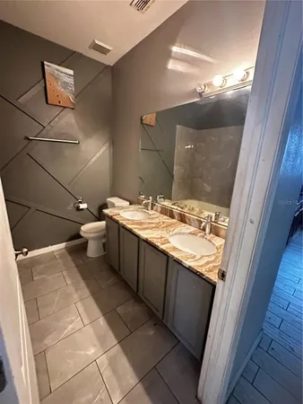 a bathroom with a sink vanity and toilet