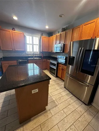a kitchen with stainless steel appliances granite countertop a refrigerator and a sink