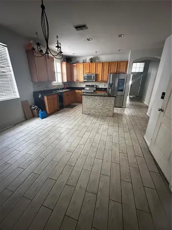 a view of a living room and kitchen with furniture wooden floor and window