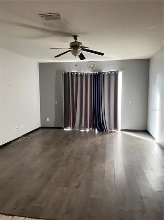 a view of an empty room with wooden floor