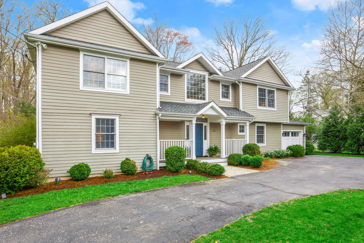 86 West Avenue Darien, CT 06820 - Photo 30 of 32 a front view of a house with a garden and plants