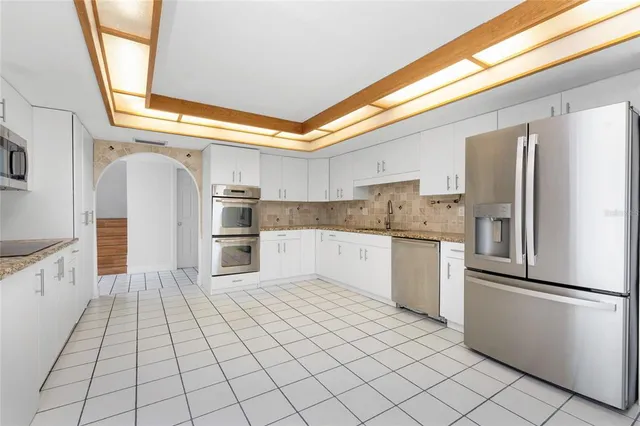an empty room with wooden floor and a fan