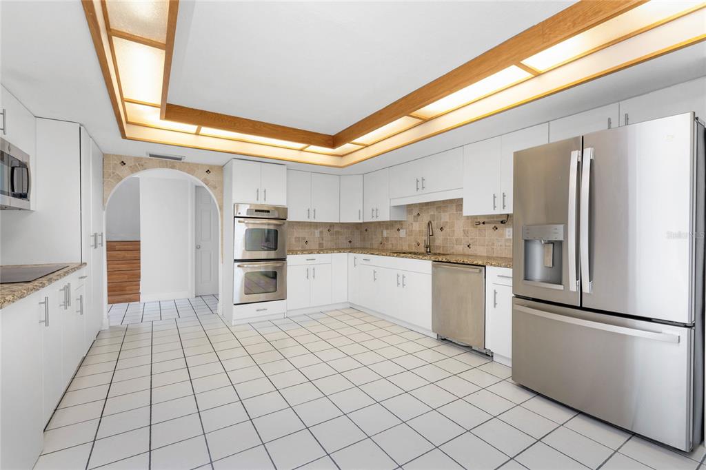 341 Severin Road Southeast Port Charlotte, FL 33952 - Photo 25 of 90 a kitchen with stainless steel appliances granite countertop a refrigerator and a stove top oven