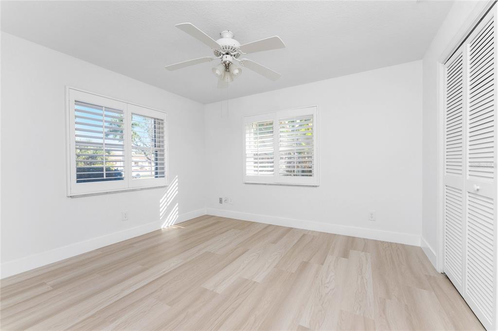 341 Severin Road Southeast Port Charlotte, FL 33952 - Photo 34 of 90 an empty room with wooden floor chandelier fan and windows