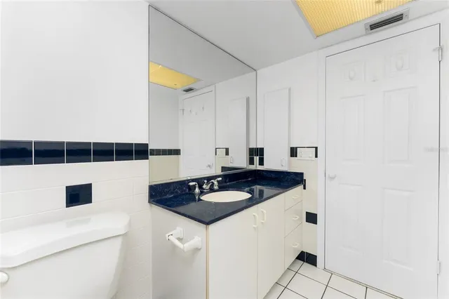 a living room with stainless steel appliances kitchen island granite countertop a refrigerator a sink a dining table and chairs with wooden floor