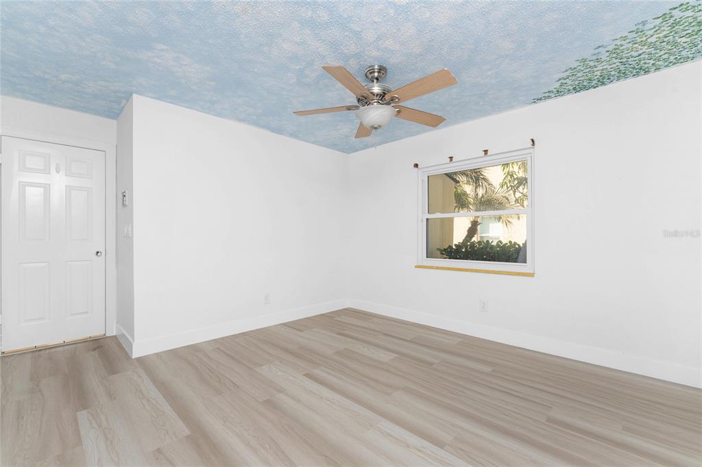 341 Severin Road Southeast Port Charlotte, FL 33952 - Photo 45 of 90 an empty room with wooden floor fan and windows