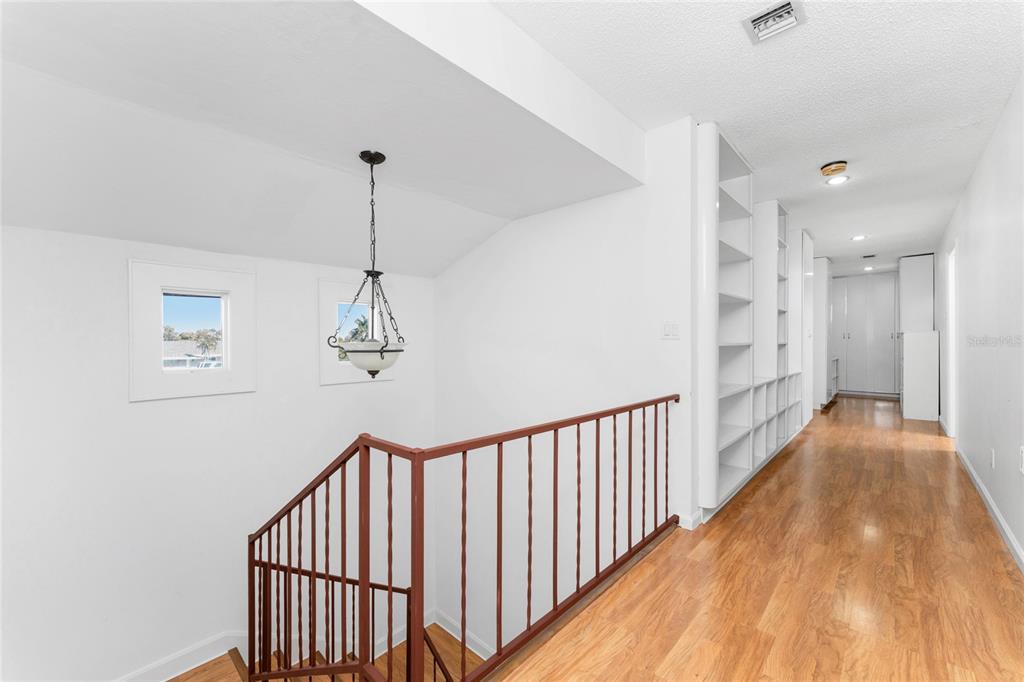 341 Severin Road Southeast Port Charlotte, FL 33952 - Photo 53 of 90 a view of a hallway with wooden floor and stairs