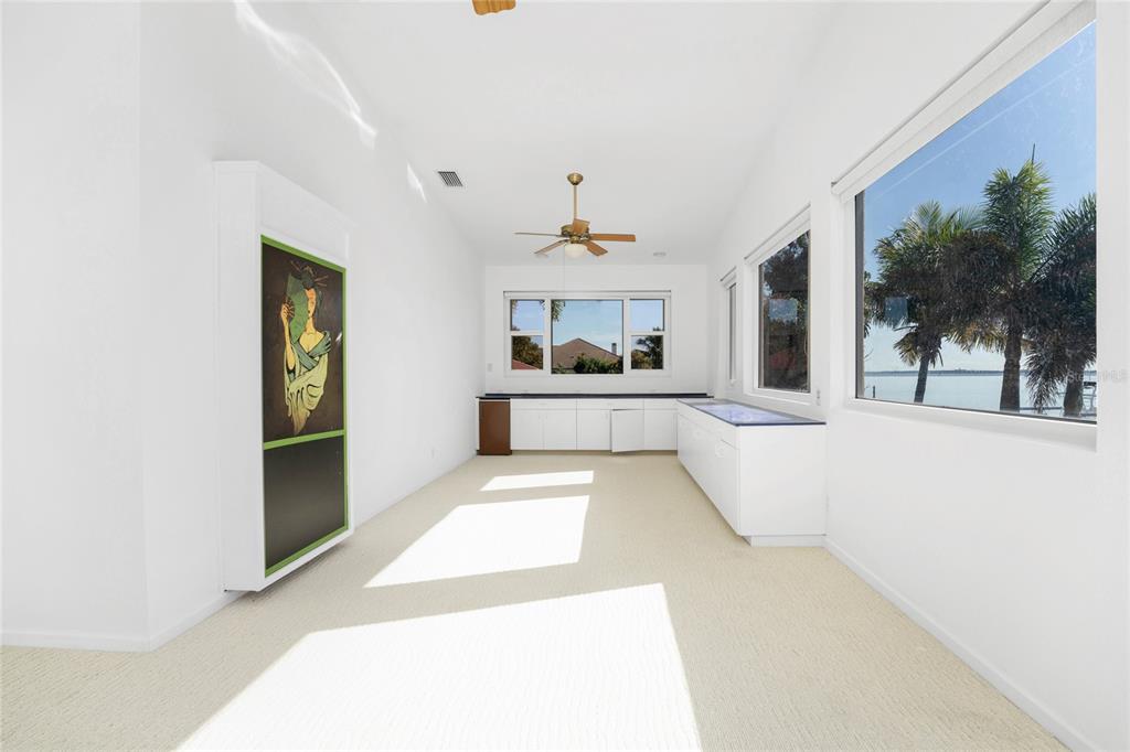 341 Severin Road Southeast Port Charlotte, FL 33952 - Photo 59 of 90 a large white kitchen with kitchen island a potted plant and a large window
