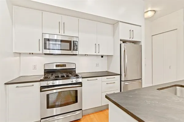 a kitchen with cabinets stainless steel appliances and a counter space