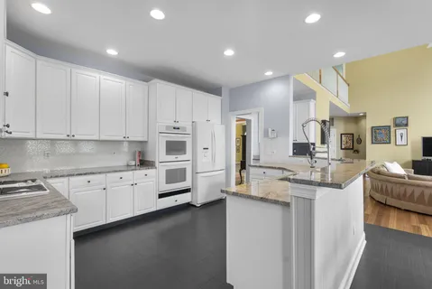 a kitchen with stainless steel appliances granite countertop a sink refrigerator and cabinets